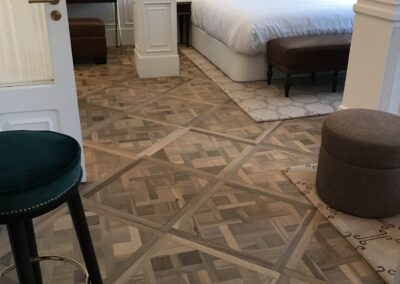 a bedroom with a bed and a stool